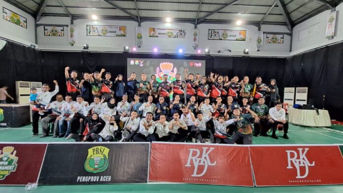 Ketua Pengprov PBSI Aceh, Safaruddin saat mengalungkan salah satu yang memperoleh juara pada Open Tournamen PBSI Aceh 2023. Foto: Ist