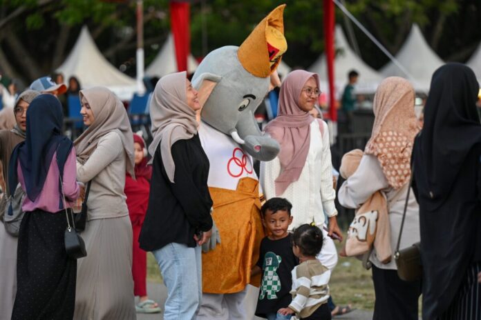 Pengunjung berfoto dengan maskot PON saat mengunjungi PON Expo di Lapangan Blang Padang, Banda Aceh, Aceh, Minggu (15/9/2024). ANTARA FOTO/Wahyu Putro A/pras.