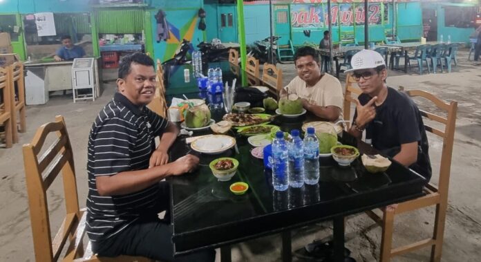 Pelatih Soft Tenis Provinsi Kalimantan Timur, Asnan, Pelatih Soft Tenis Kalimantan Utara, Seno, dan Liaison Officer Soft Tenis Kaltara, Naufal Habibi, sedang menikmati makan malam di Restoran Awak Awai, Lamnyong